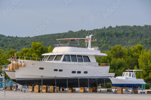 Large white motor yacht on dry dock for maintenance and winter storage