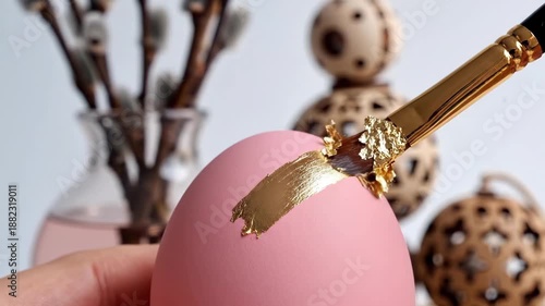 Hands Decorating Pink Easter Egg with Luxury Gold Leaf Stroke