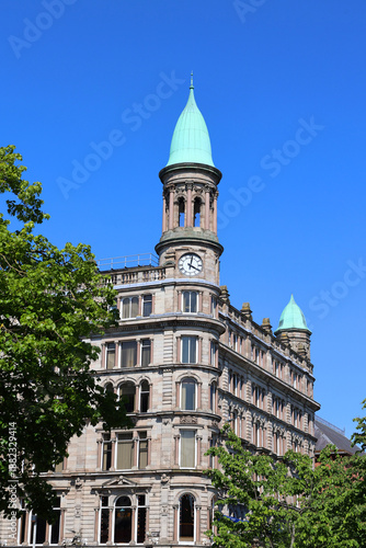 BELFAST NORTHERN IRELAND UNITED KINGDOM. Green copper ogee dome and tower clock on old Robinson and Cleavers department store in belfast designed by Young and Mackenzie