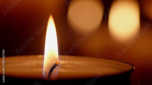 A candle burning warmly in a dark room