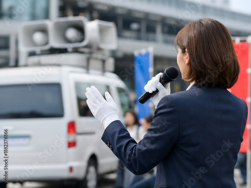 街頭演説を行う女性候補者の後ろ姿