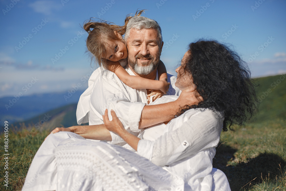 Fototapeta premium Grandparents in summer mountains with granddaughter