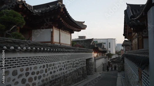 View of restored traditional houses in Bukchon Hanok Village with N Seoul Tower in background at sunset, Jongno District, Seoul, South Korea, Asia