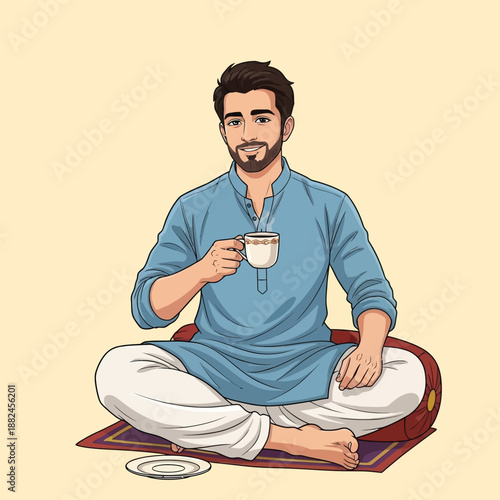 A young man with a beard, dressed in traditional South Asian attire, sits cross-legged on a mat, enjoying a warm cup of tea or coffee.