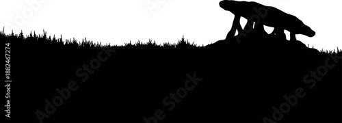 Ancient dolmen prehistoric stone monument silhouette on a grassy hill.