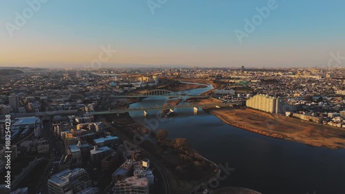夕暮れの多摩川上空、登戸と和泉多摩川を結ぶ鉄橋（ドローン空撮）