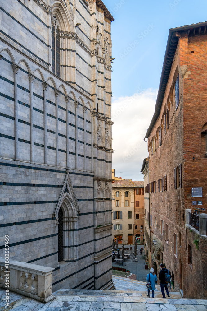 Fototapeta premium Siena Cathedral side view and historic Siena street in Italy
