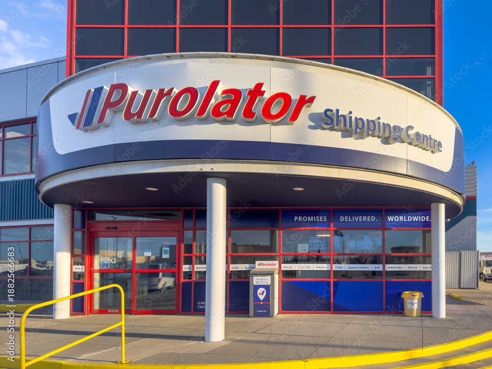 Fototapeta premium Calgary, Alberta, Canada. Jan 19, 2026. Exterior of a Purolator Shipping Centre building with blue and red corporate branding and glass windows.