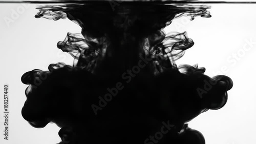 Ink droplet splashing in water creating abstract shape