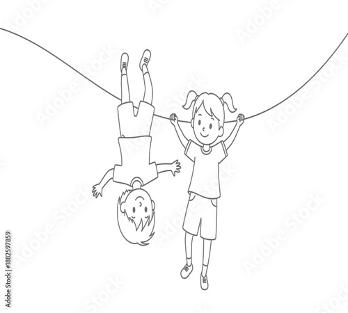 Two children playing on a rope one hanging upside down enjoying a carefree moment