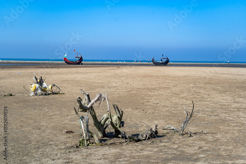 Traditional Moon Boat (Sampan) Beached on the Shores of Teknaf, Cox's Bazar. Colorful Wooden Fishing Boat on a Sandy Beach under Clear Blue Sky in Bangladesh. Vibrant Traditional Fishing Vessel on the