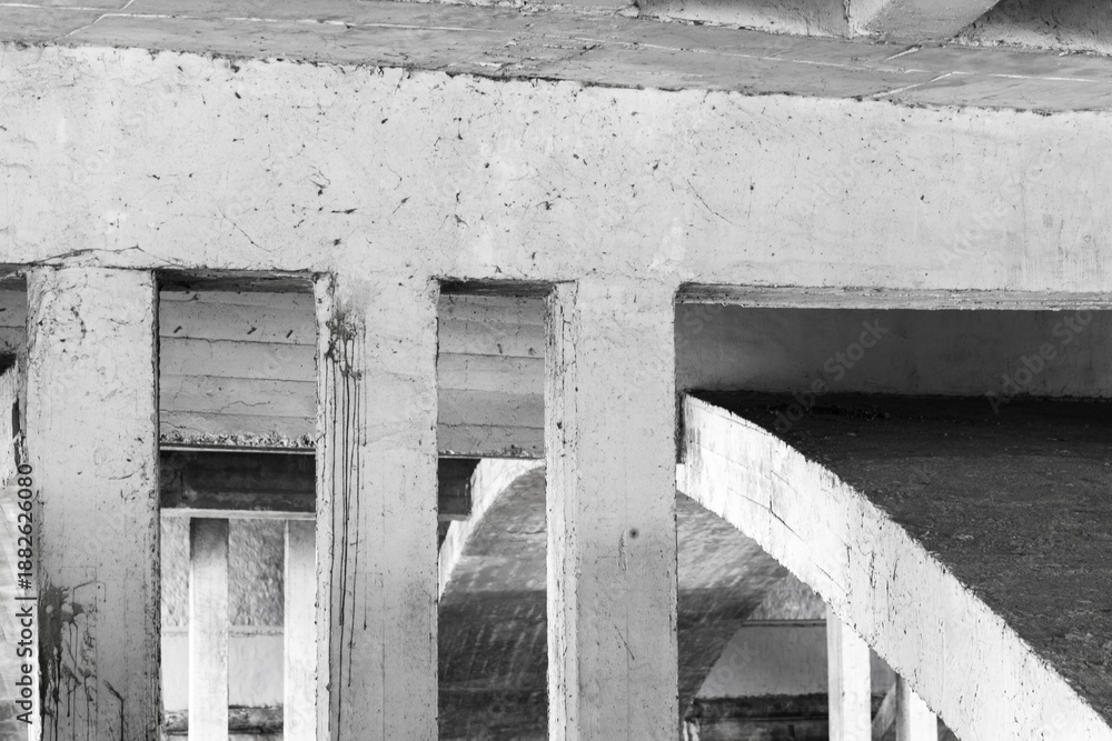 Obraz premium Monochrome scene showing rugged concrete pillars and curved ramp