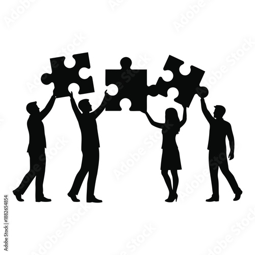 Silhouette of four business people holding up puzzle pieces in a team working together