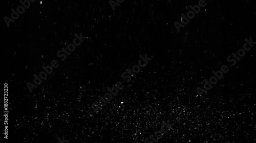 Raindrops falling on the ground on black background