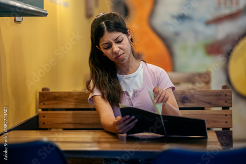 Εκτύπωση καμβά Young woman finding difficulty choosing from menu