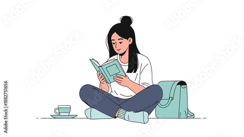 Young woman sits on the floor while reading a green book with her backpack and a cup of tea nearby in a peaceful indoor setting.