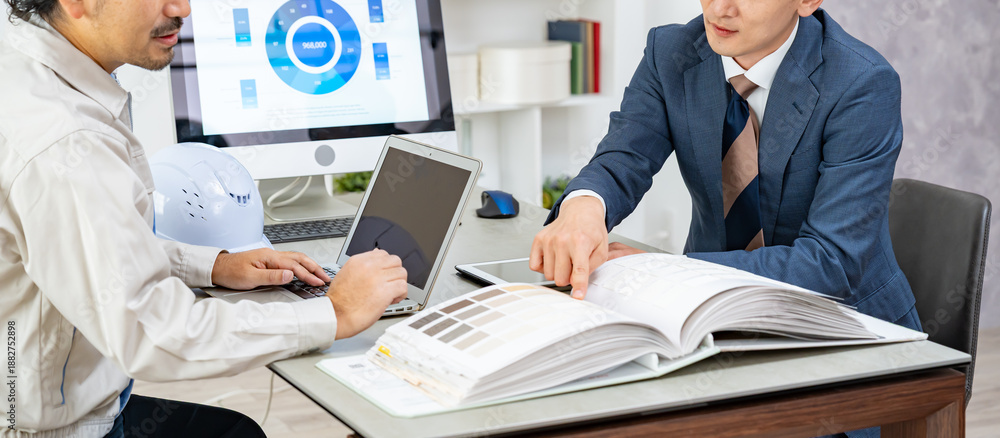 Fototapeta premium 打ち合わせをする作業着、スーツを男性たち