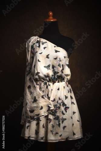 One shoulder dress with butterfly print on a mannequin display