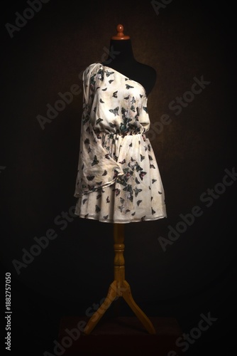 One shoulder dress with butterfly print on a mannequin display
