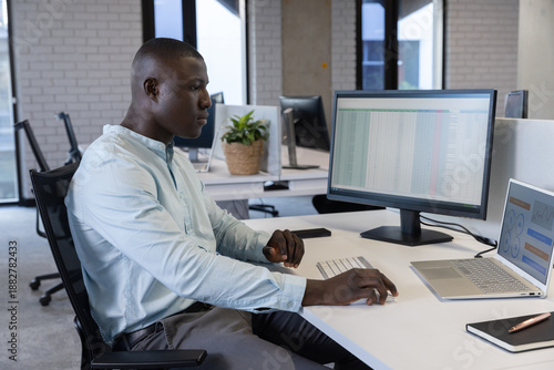 Schilderij op canvas African American man working on spreadsheet on external monitor at modern office