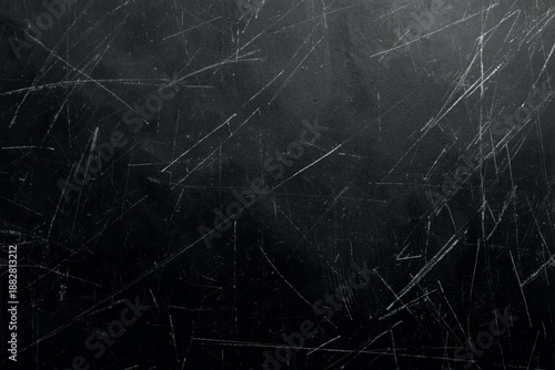 A dark abstract background featuring numerous scratches and textured lines across surface