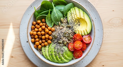 Top-down food photo of a plant-based vegan bowl made with quinoa, chickpeas, avocado, and vegetables, representing healthy eating and sustainability.