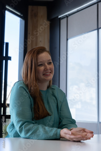 Mid adult woman smiling while gesturing over conference table in office with large windows Free Download Mid adult woman smiling while gesturing over conference table in office with large windows - GFXLoad