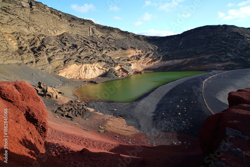 Lago Verde (Green lake) at sunset, surrounded by colorful landscape with volcanic rocks in El Golfo, Lanzarote, Canary Islands, Spain