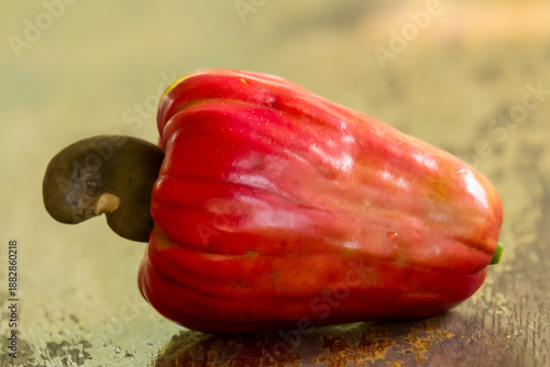 Red cashew fruit on a wooden table, close-up.