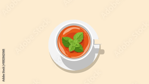 Overhead view of a white cup filled with red liquid and mint leaves