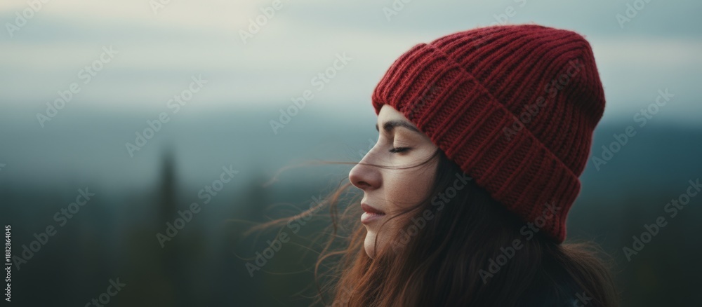 Obraz premium Tranquil Mountain Woman, Peaceful Lady In Scarlet Cap Looks Over Fogcovered Mountains, Relaxed Woman Wearing Crimson Beanie Admires Misty Mountain Landscape In Silence And Serenity