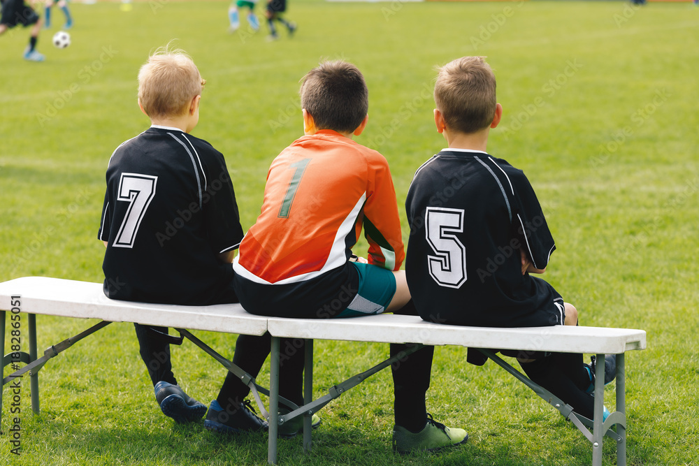 Obraz premium Football soccer match for children. Kids waiting on a bench
