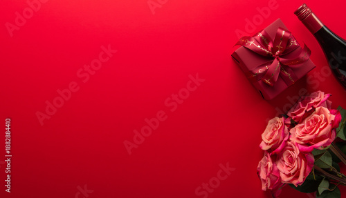 Gift, present box with red ribbon bow, rose flowers and wine bottle on red background top view. Valentine's day, 14 February, birthday, 8 march women's day gift. Love and romance.