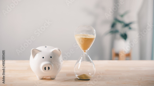 Bild auf Leinwand Hourglass with piggy bank and saving money to reduce company cost, business budg