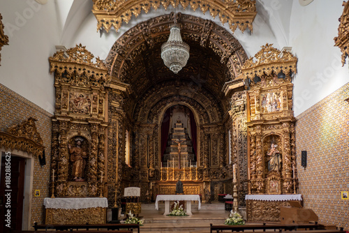 Foto Interior do altar-mor e retábulos laterais em talha dourada barroca da Igreja da
