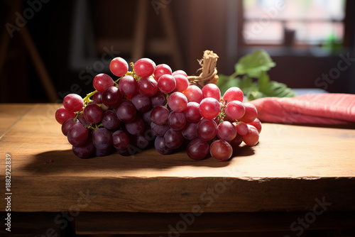 Cluster of Fresh Red Grapes with Stem on Rustic Wooden Table in Soft Daylight