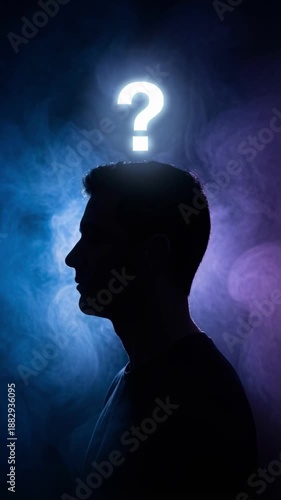 Silhouette of a man with a glowing question mark above his head. Swirling blue and purple smoke in a dark background. Concept of thinking, confusion, and problem solving. Vertical footage