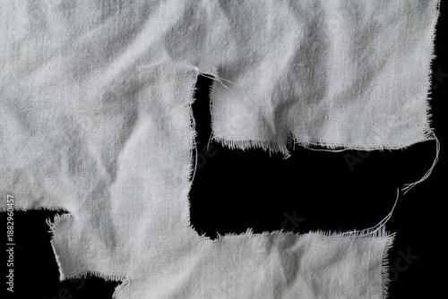 Schilderij op canvas torn old white rag with holes on a black background, canvas