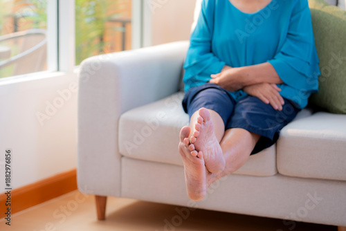 Wallpaper Mural Close up leg senior woman practice stretch leg for treatment knee pain sitting on sofa in living room at home, physical therapy routine knee and leg strength of elderly, rehabilitation and self care. Torontodigital.ca
