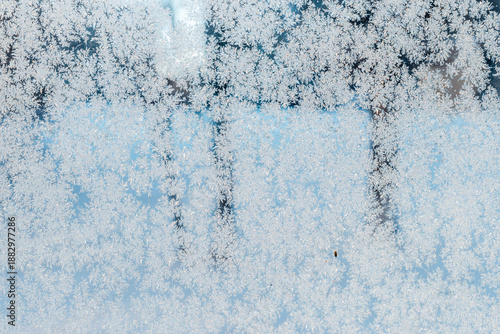 Frosted winter window with frozen snowflake texture.