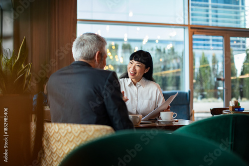 Business colleagues meeting over coffee in modern cafe