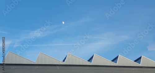 Geometric triangular industrial factory roof under moon. Mobile photography, real phone snapshot