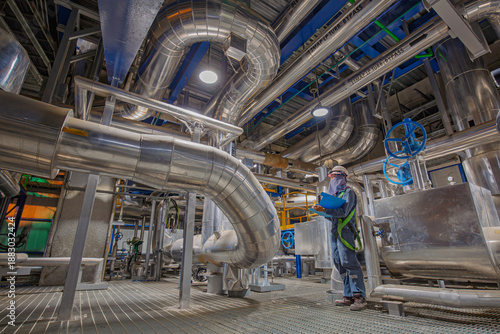 Male worker inspection at steel long pipes insulation and pipe elbow in station oil factory during refinery valve of visual check record