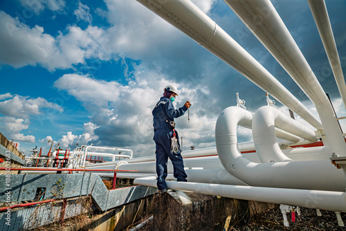 Production operator opening ball valve at pipeline oil and gas wellhead remote platform to control gases