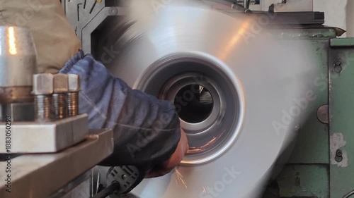 skilled worker grinding a large steel mold on a lathe video with sound