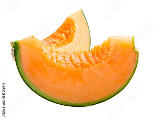 Two bright orange cantaloupe slices with green rind on black