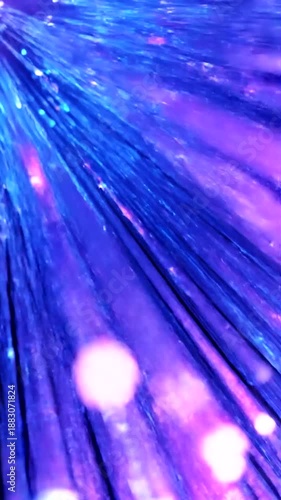 Fiber Optic Cables Illuminating with Blue and Purple Light on a Reflective Surface.