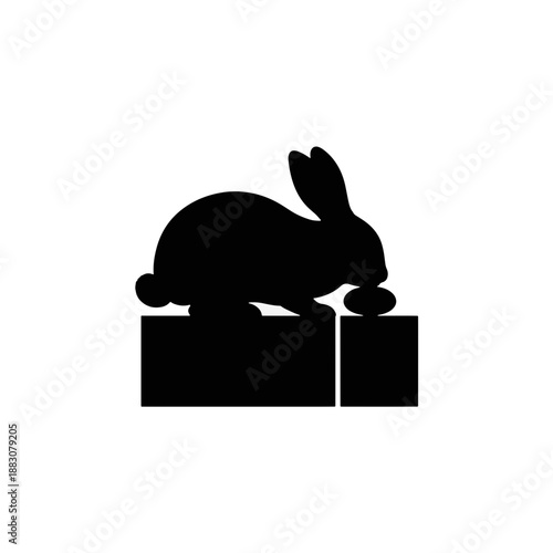 Rabbit silhouette chewing on a cardboard box. Solid black shape vector illustration. Flat design icon isolated on transparent background
