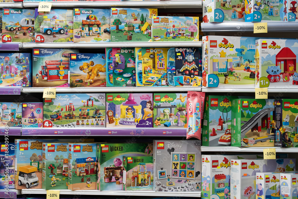 Naklejka premium Lego products on a shelf in a shop. Various LEGO boxes, including City, Friends, Duplo and Disney themes, are neatly arranged on store shelves, ready for purchase. Minsk, Belarus - March 4, 2025