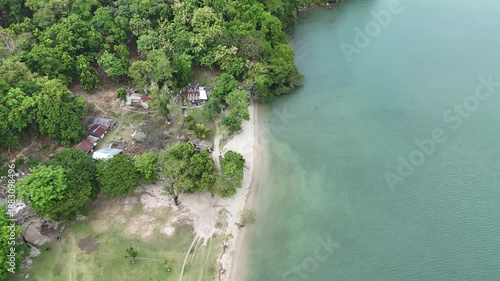 Aerial View Of A Tropical Beach Village With Lush Green Trees And Turquoise Water During Daytime